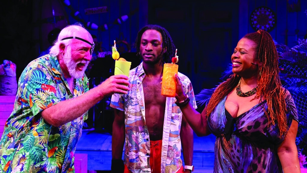 Three cast members of Escape to Margaritaville at Theatre Workshop of Nantucket toasting with colorful tropical drinks on stage