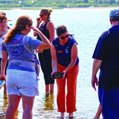 A naturalist photographs wildlife in a Nantucket habitat during the 2026 BioBlitz inter-island biodiversity competition using the iNaturalist app.