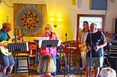 Some Wicked Rusty performing at a Nantucket rehearsal, with LeeAnn Papale-Kalman on vocals, Rick Kalman on guitar, and bandmates on bass and drums