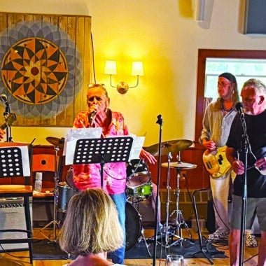 Some Wicked Rusty performing at a Nantucket rehearsal, with LeeAnn Papale-Kalman on vocals, Rick Kalman on guitar, and bandmates on bass and drums