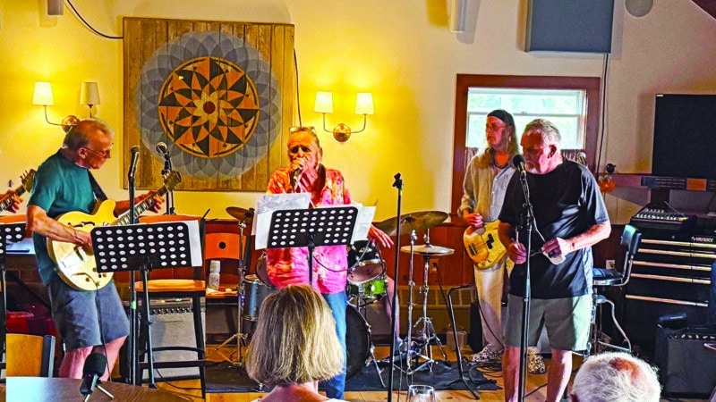 Some Wicked Rusty performing at a Nantucket rehearsal, with LeeAnn Papale-Kalman on vocals, Rick Kalman on guitar, and bandmates on bass and drums