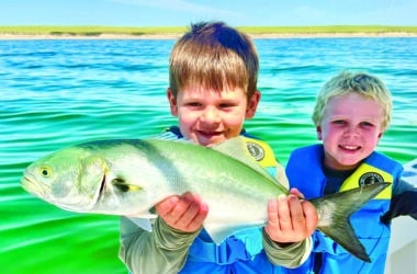 Two young anglers proudly hold up a bluefish caught during the August Blues Nantucket Fishing Tournament.