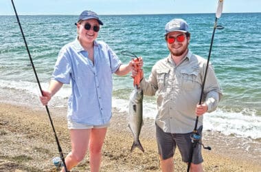Nantucket musician Gabe Zinzer and fiddler Emma Buckner hold up a bluefish caught during her visit to Great Point.