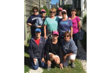 Nine longtime friends pose together on Nantucket during their annual girls' weekend tradition.