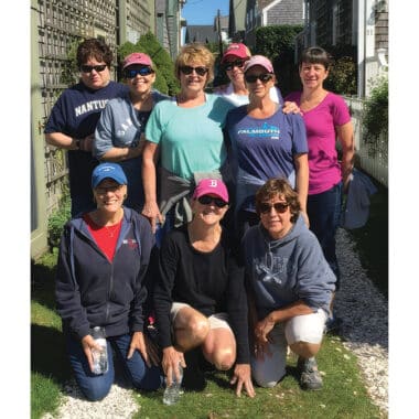 Nine longtime friends pose together on Nantucket during their annual girls' weekend tradition.