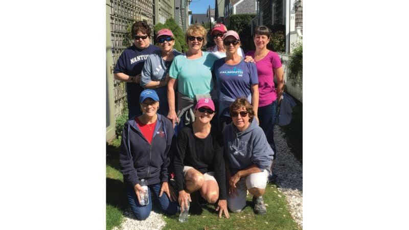 Nine longtime friends pose together on Nantucket during their annual girls' weekend tradition.