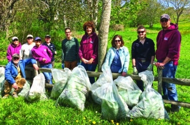 IPSC volunteers pose with bagged garlic mustard after a Nantucket invasive plant removal event in 2016.