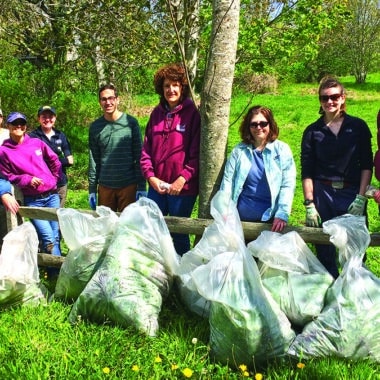 IPSC volunteers pose with bagged garlic mustard after a Nantucket invasive plant removal event in 2016.