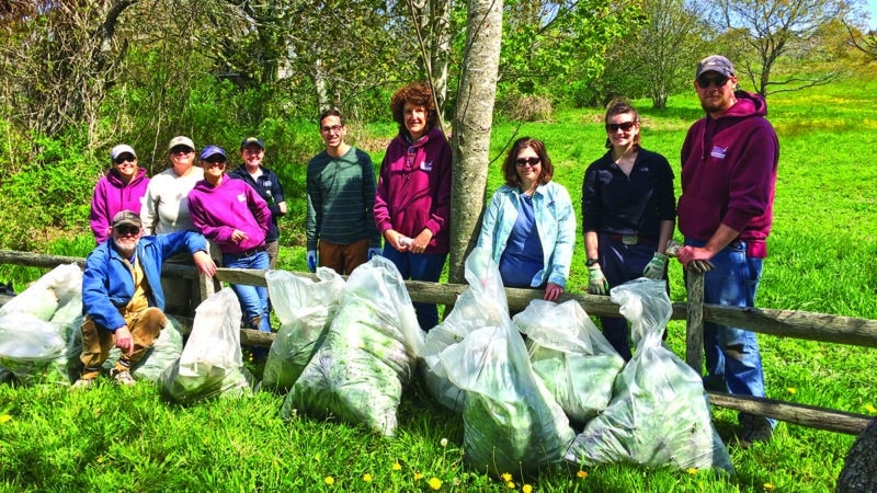 IPSC volunteers pose with bagged garlic mustard after a Nantucket invasive plant removal event in 2016.