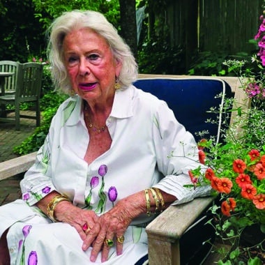 Nantucket jeweler Susan Lister Locke sits in her garden wearing gold bracelets and rings from her own collection.