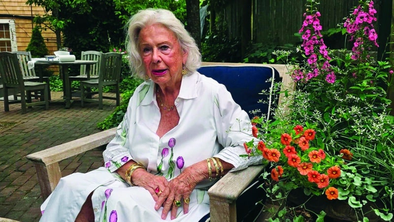 Nantucket jeweler Susan Lister Locke sits in her garden wearing gold bracelets and rings from her own collection.