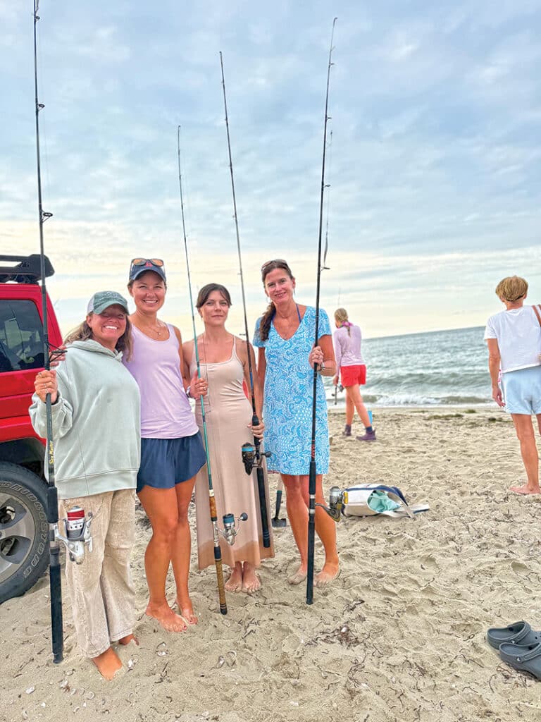 Attendees pose with their fishing rods at Tammy King's women's fishing seminar on Nantucket.